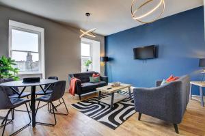 uma sala de estar com paredes azuis e uma mesa e cadeiras em Coorie Doon - Aparthotel - Troon em Troon