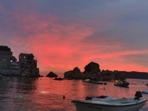 a sunset over a body of water with boats at Lux Beach House M in Pržno +21 photos