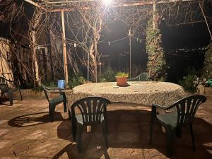 einen Tisch und Stühle auf einer Terrasse in der Nacht in der Unterkunft Villa Castello in Montefalcione