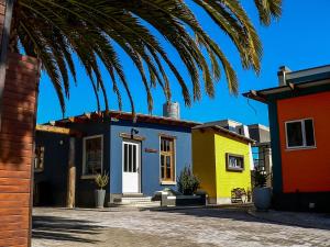 a row of colorful houses with a palm tree at de Baken Self-Catering in Walvis Bay