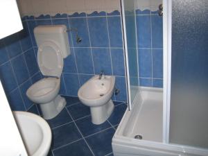 a blue tiled bathroom with a toilet and a sink at Apartment Volme in Pula +43 photos