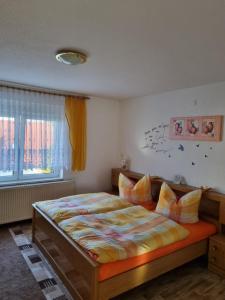 a bedroom with a bed and a window at Ferienhaus in Thüringen Nähe Hohenwarte Stausee in Unterwellenborn