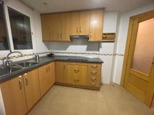a kitchen with wooden cabinets and a sink at FH CAMP PRECIÓS I in Altea