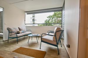 - un salon avec deux chaises, une table et une fenêtre dans l'établissement La Suite Azur, à Pointe-à-Pitre