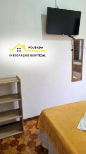 a room with a flat screen tv on a wall at Pousada Integração Buritizal in Buritizal