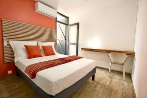a bedroom with a bed with orange walls and a chair at La Suite Azur in Pointe-à-Pitre