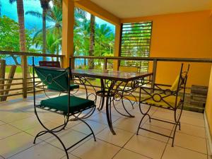 um alpendre com uma mesa e cadeiras numa varanda em La Villa Lou, Musée Des Arts Grand Batangua em Kribi