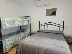 a bedroom with a bed and a bunk bed at Llar de Laura in El Poblenou del Delta