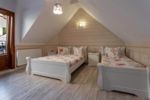 2 Betten in einem Zimmer mit Dachgeschoss in der Unterkunft Willa Grono in Krościenko nad Dunajcem