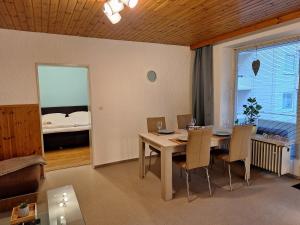a dining room with a table and chairs and a bed at FeWo Berg-Domizil Bad Harzburg mit eigenem Fahrradkeller und Parkplatz, inklusive Bettwäsche und Handtüchern in Bad Harzburg +13 photos