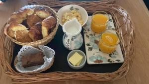 a basket of food with bread and two glasses of orange juice at Apart Lo de Jose in Tandil