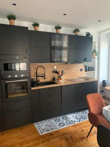 a kitchen with gray cabinets and a sink at Le RIVA Cherbourg Centre in Cherbourg en Cotentin