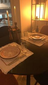 a table with two plates and a candle on it at Le RIVA Cherbourg Centre in Cherbourg en Cotentin