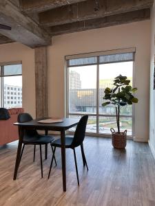 a dining room with a table and chairs and a plant at The Best of Downtown Living in Baton Rouge