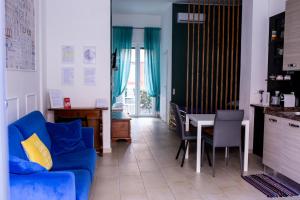 een woonkamer met een blauwe bank en een tafel bij Bologna Travel Suite in Bologna