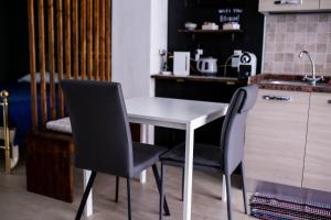 cocina con mesa blanca y 2 sillas en Bologna Travel Suite en Bolonia