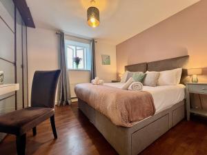 ein Schlafzimmer mit einem Bett und einem Stuhl und einem Fenster in der Unterkunft The Orchid-Central Beeston-Private Apartment-SmartTV-Free Wi-Fi-Tram-Parking in Nottingham