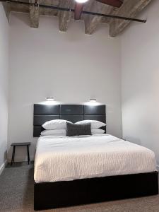 a bedroom with a large bed with a black headboard at The Best of Downtown Living in Baton Rouge