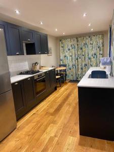 a kitchen with black cabinets and a wooden floor at 2 bedroom cottage in Stamford in Lincolnshire