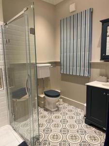a bathroom with a toilet and a glass shower at 2 bedroom cottage in Stamford in Lincolnshire