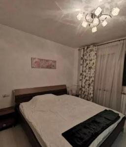 a bedroom with a bed and a chandelier at Apartament Superb Orizont in Bacău