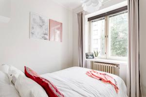 ein Schlafzimmer mit einem Bett mit roten Kissen darauf in der Unterkunft Quaint Kallio Hideaway in Amazing Location in Helsinki