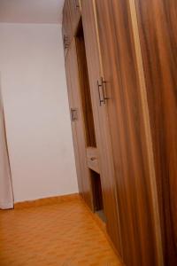 a closet with wooden doors in a room at Deci Homes in Ruaka
