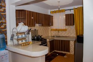 a kitchen with wooden cabinets and a counter top at Deci Homes in Ruaka