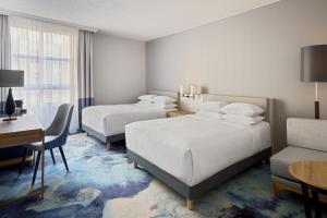 ein Hotelzimmer mit 2 Betten und einem Schreibtisch in der Unterkunft Hamburg Marriott Hotel in Hamburg