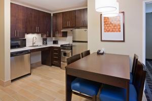 a kitchen with a wooden table and a dining room at TownePlace Suites by Marriott Sioux Falls South in Sioux Falls +9 photos
