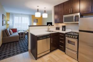cocina con electrodomésticos de acero inoxidable y sala de estar. en TownePlace Suites by Marriott Sioux Falls South, en Sioux Falls