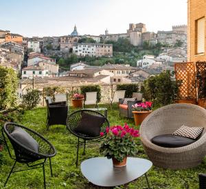 a group of chairs and tables with a view of a city at Hotel Minerva in Siena