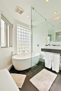 Baño blanco con bañera y espejo en Double Ocean View Villa Laguna Beach, en Laguna Beach 37 fotos más