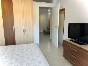 um quarto com uma televisão de ecrã plano numa cómoda em DESA Seaside Apartment em Vlorë