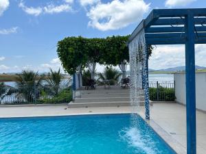 a swimming pool with a water fountain at Casa Florida do Lago in Guapé