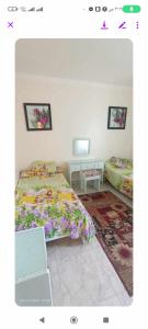 a bedroom with two beds and two tables at فيلا دوبلكس على البحر مباشره in Arish