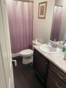 a bathroom with a pink shower curtain and a toilet at Beautiful 3bedroom & loft home with mountains view in Denver