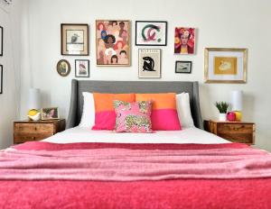 a bedroom with a large bed with pink and orange pillows at Spotless Modern Home Close to LAX & Sofi Stadium in Inglewood
