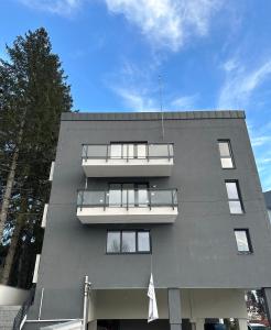 un edificio gris con balcones a un lado en Apartament Bonton Predeal, en Predeal