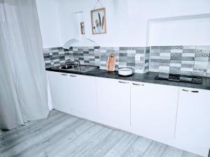 uma cozinha com armários brancos e um balcão preto em Refuge Parfumé Cosy 4 couchages Parking em Grasse