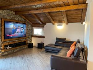 sala de estar con sofá y TV de pantalla plana en TIVANIA DREAM - Hi-end modern attic, en Zelbio