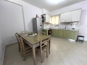 uma cozinha com uma mesa e cadeiras e um frigorífico em DESA Seaside Apartment em Vlorë