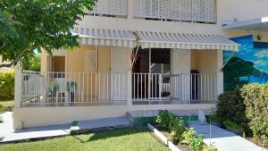 a house with a white fence in front of it at T2 Bas de villa Les Hibiscus in Sainte-Anne