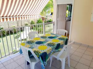 un balcon avec une table, une table et des chaises dans l'établissement T2 Bas de villa Les Hibiscus, à Sainte-Anne