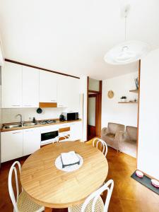 une cuisine et une salle à manger avec une table et des chaises en bois dans l'établissement Luminoso, Versilia, Vicino al Mare, à Marina di Carrara