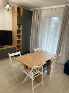 a wooden table and chairs in a living room at Apartament Bonton Predeal in Predeal