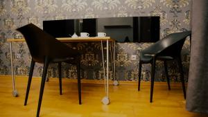 Extravagant apartment in Prague في براغ: كرسيان سودان يجلسون على طاولة مع مرآة