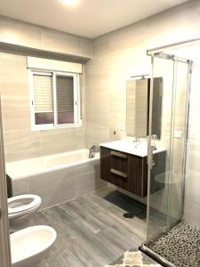 a bathroom with a toilet and a sink and a shower at Modern Apartment in Alicante center Beach in Alicante