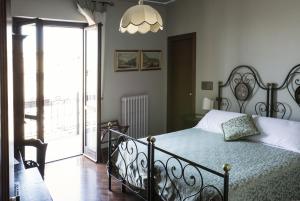 a bedroom with a bed with a wrought iron frame at La Locanda Del Capitano in Montone