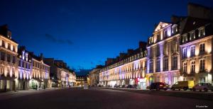 a city street with buildings lit up at night at Charmant Cocon au coeur de Caen in Caen